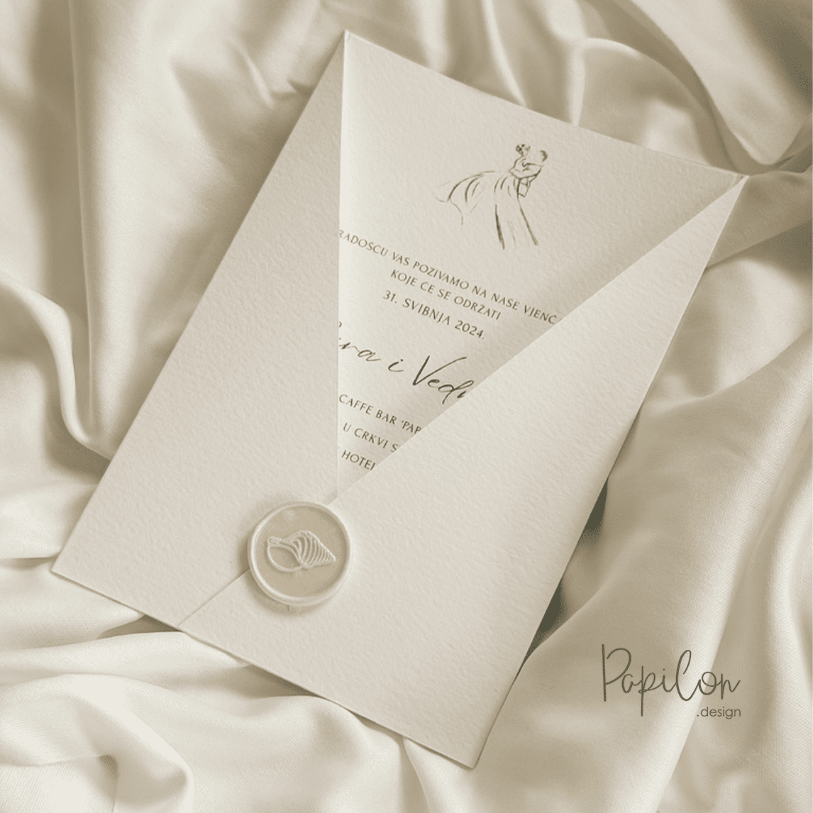 Delicate wedding invitation in a white textured sleeve with a wax seal